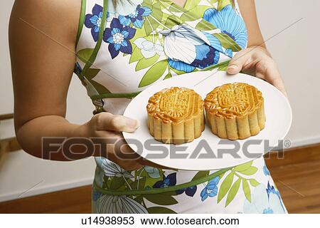 Mid section view of a young woman holding cup cakes in a plate View Large Photo Image Stock Image - Mid section view of a young woman holding cup cakes in a plate. Fotosearch