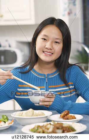 Portrait of a girl holding a pair of chopsticks and a bowl View Large Photo Image Stock Photography - Portrait of a girl holding a pair of chopsticks and a bowl. Fotosearch
