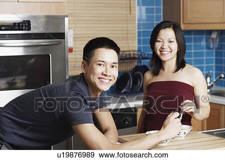 Portrait of a young couple smiling in the kitchen View Large Photo Image Stock Photo - Portrait of a young couple smiling in the kitchen. Fotosearch