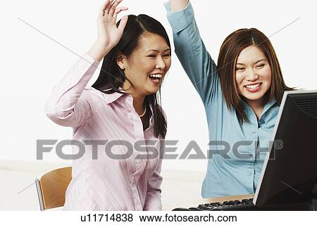 Close-up of two businesswomen smiling with their hands raised View Large Photo Image Stock Photo - Close-up of two businesswomen smiling with their hands raised. Fotosearch