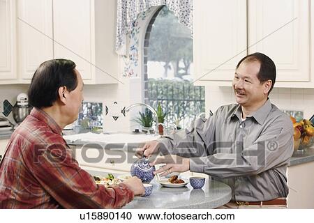 Stock Image - Close-up of two senior men at the table. Fotosearch