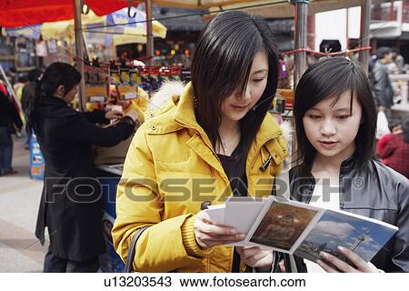 Close-up of two young women reading a greeting card at a market stall View Large Photo Image Stock Image - Close-up of two young women reading a greeting card at a market stall. Fotosearch