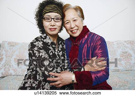 Stock Photography - Portrait of two mature women hugging each other. Fotosearch
