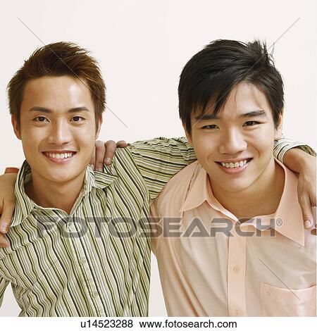 Stock Photo - Portrait of two young men and a mid adult man posing and smiling. Fotosearch