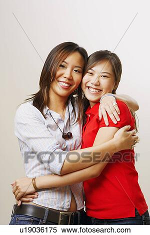 Portrait of two young women hugging each other and looking cheerful View Large Photo Image Stock Photography - Portrait of two young women hugging each other and looking cheerful. Fotosearch