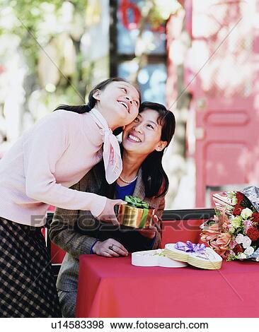Stock Photo - Two young women holding a gift. Fotosearch