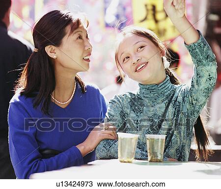Two young women sitting in a restaurant and looking up View Large Photo Image Stock Image - Two young women sitting in a restaurant and looking up. Fotosearch