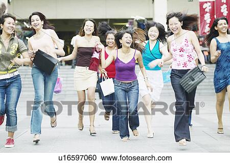 Group of young women running with shopping bags View Large Photo Image Stock Image - Group of young women running with shopping bags. Fotosearch