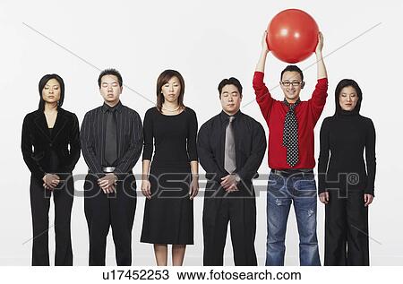 Portrait of a young man standing holding a ball with a group of business executives View Large Photo Image Stock Image - Portrait of a young man standing holding a ball with a group of business executives. Fotosearch