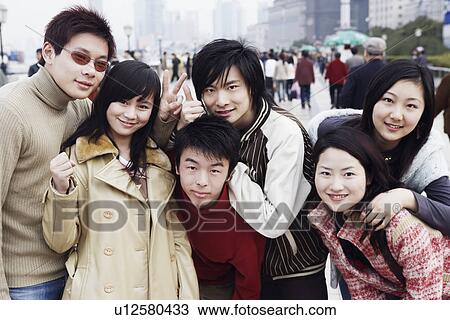 Stock Image - Portrait of three young men and three young women smiling. Fotosearch