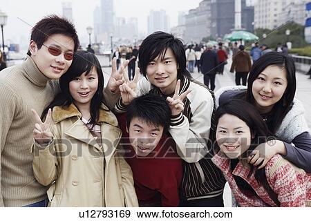 Stock Photo - Portrait of three young men and three young women showing the peace sign. Fotosearch