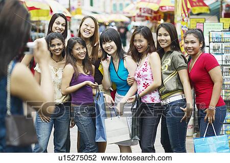 Young woman taking a photograph of her friends View Large Photo Image Stock Image - Young woman taking a photograph of her friends. Fotosearch