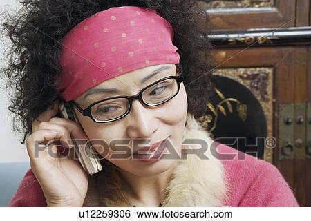Close-up of a mature woman talking on a mobile phone View Large Photo Image Stock Photograph - Close-up of a mature woman talking on a mobile phone. Fotosearch