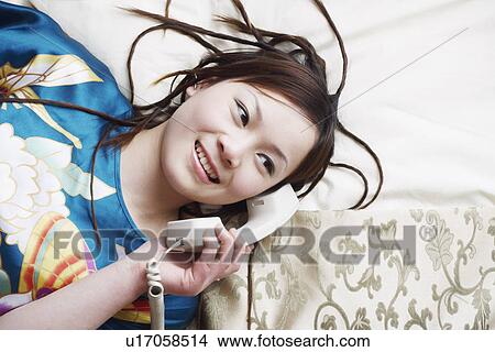 High angle view of a young woman talking on the telephone View Large Photo Image Picture - High angle view of a young woman talking on the telephone. Fotosearch