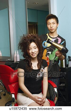 Portrait of a male hairdresser drying hair of a young woman View Large Photo Image Stock Photography - Portrait of a male hairdresser drying hair of a young woman. Fotosearch