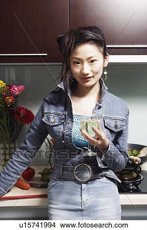 Portrait of a young woman holding a wineglass View Large Photo Image Picture - Portrait of a young woman holding a wineglass. Fotosearch