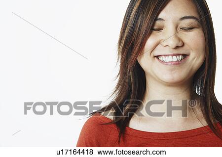 Close-up of a mid adult woman smiling with her eyes closed View Large Photo Image Stock Photo - Close-up of a mid adult woman smiling with her eyes closed. Fotosearch