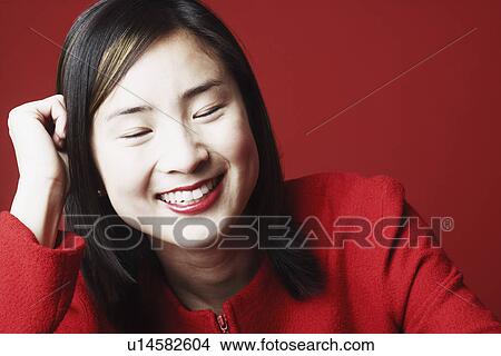 Picture - Close-up of a young woman smiling with her eyes closed. Fotosearch