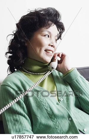 Close-up of a businesswoman using a telephone smiling View Large Photo Image Stock Photo - Close-up of a businesswoman using a telephone smiling. Fotosearch