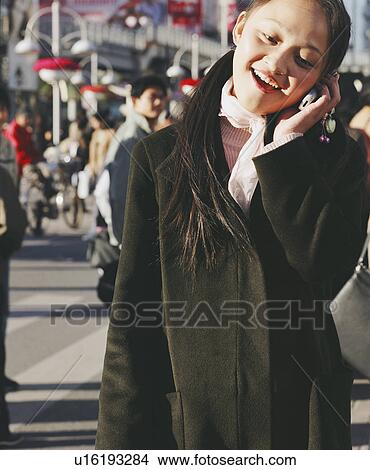 Picture - Close-up of a young woman talking on a mobile phone. Fotosearch