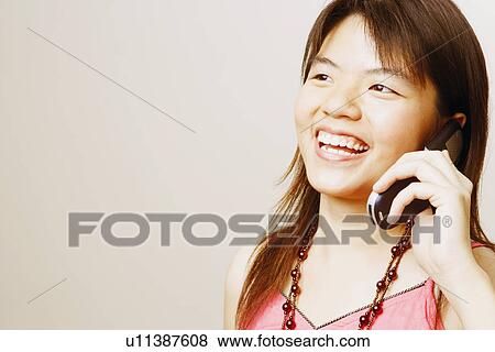 Stock Photo - Close-up of a young woman talking on a mobile phone. Fotosearch
