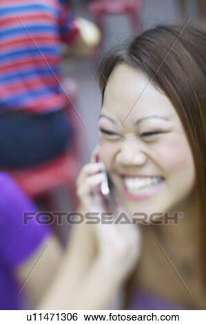 Close-up of a young woman talking on a mobile phone View Large Photo Image Stock Photograph - Close-up of a young woman talking on a mobile phone. Fotosearch