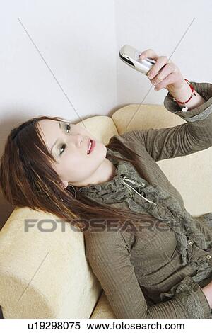 High angle view of a young woman looking at a mobile phone View Large Photo Image Stock Photography - High angle view of a young woman looking at a mobile phone. Fotosearch