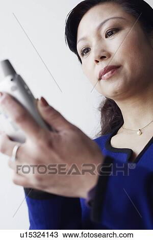 Low angle view of a mature woman operating a mobile phone View Large Photo Image Stock Image - Low angle view of a mature woman operating a mobile phone. Fotosearch