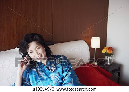 Stock Image - Portrait of a mature woman talking on a mobile phone. Fotosearch