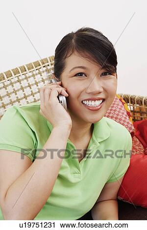 Stock Image - Portrait of a young woman talking on a mobile phone. Fotosearch