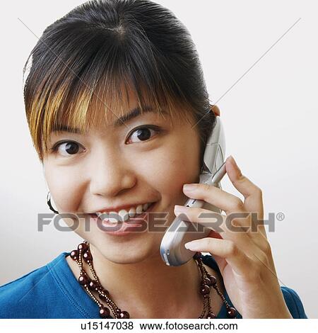 Portrait of a young woman talking on a mobile phone View Large Photo Image Stock Photo - Portrait of a young woman talking on a mobile phone. Fotosearch