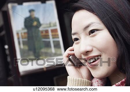 Side profile of a young woman using a mobile phone View Large Photo Image Stock Photo - Side profile of a young woman using a mobile phone. Fotosearch