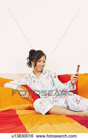 Young woman looking at a mobile phone View Large Photo Image Stock Photograph - Young woman looking at a mobile phone. Fotosearch