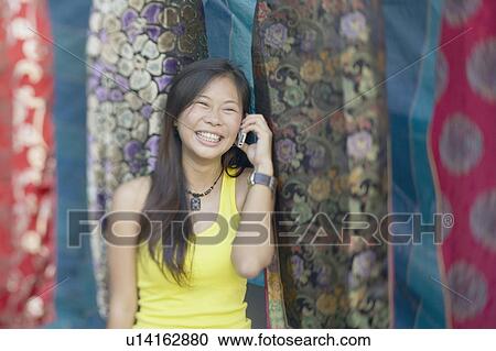 Stock Image - Young woman talking on a mobile phone. Fotosearch