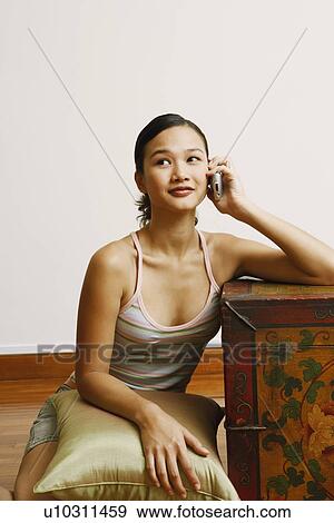 Young woman talking on a mobile phone View Large Photo Image Stock Photo - Young woman talking on a mobile phone. Fotosearch