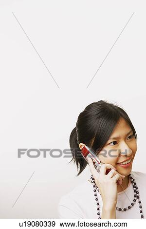 Stock Photo - Young woman talking on a mobile phone. Fotosearch