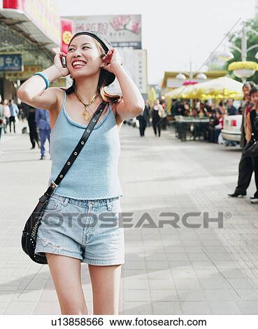 Stock Photograph - Young woman talking on a mobile phone. Fotosearch