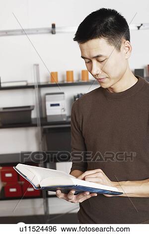 Close-up of a businessman reading a book View Large Photo Image Stock Photograph - Close-up of a businessman reading a book. Fotosearch