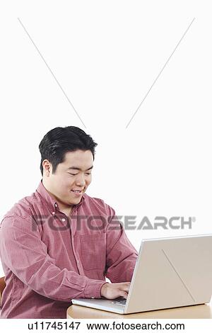 Stock Photo - Close-up of a businessman using a laptop. Fotosearch