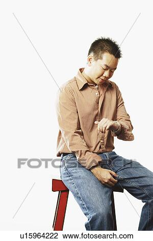 Close-up of a young man looking at his wrist watch View Large Photo Image Stock Image - Close-up of a young man looking at his wrist watch. Fotosearch