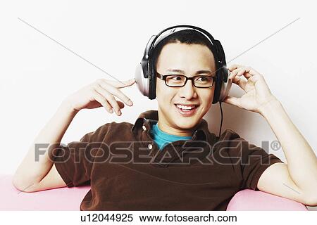 Stock Photography - Close-up of a young man wearing headphones. Fotosearch
