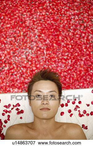 Portrait of a young man lying on floor near a hot tub filled with rose petals View Large Photo Image Stock Photo - Portrait of a young man lying on floor near a hot tub filled with rose petals. Fotosearch