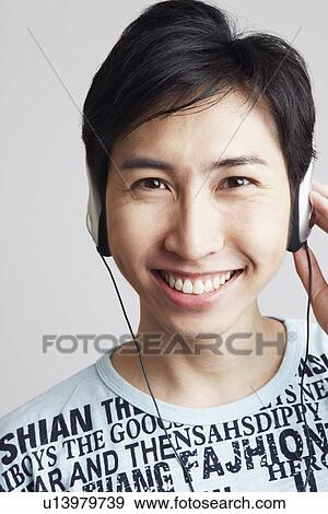 Portrait of a young man wearing headphones and listening to music View Large Photo Image Stock Photo - Portrait of a young man wearing headphones and listening to music. Fotosearch