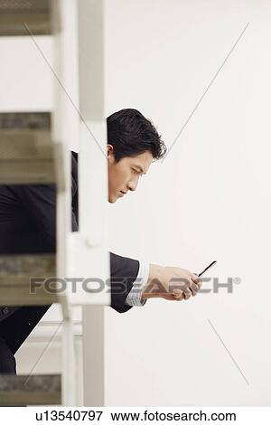 Side profile of a businessman using a mobile phone View Large Photo Image Stock Photo - Side profile of a businessman using a mobile phone. Fotosearch