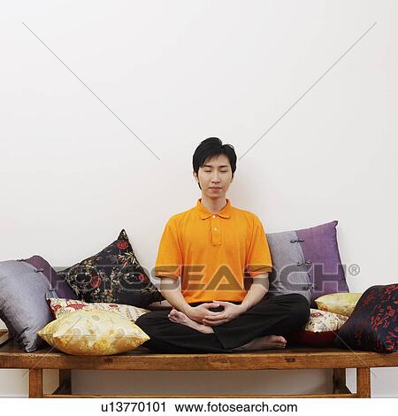 Young man sitting on a bench with his eyes closed View Large Photo Image Stock Image - Young man sitting on a bench with his eyes closed. Fotosearch
