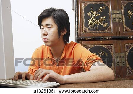 Stock Image - Young man using a computer. Fotosearch