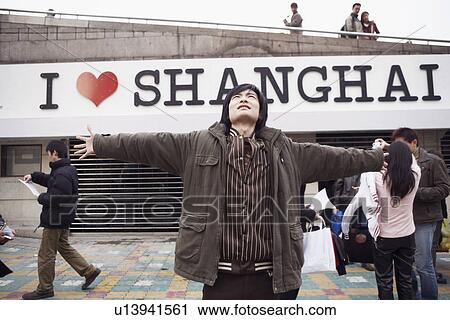 Stock Image - Young man with his arms outstretched looking up. Fotosearch