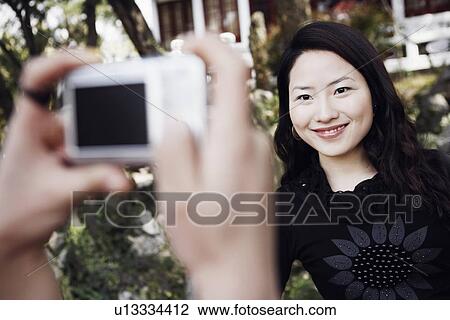 Close-up of a person's hand taking a photograph of a young woman smiling View Large Photo Image Stock Image - Close-up of a person's hand taking a photograph of a young woman smiling. Fotosearch