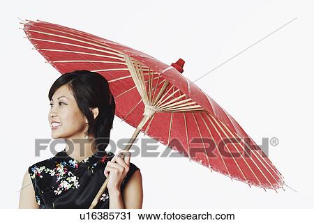 Close-up of a young woman holding a parasol View Large Photo Image Stock Image - Close-up of a young woman holding a parasol. Fotosearch