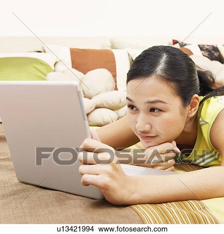 Close-up of a young woman looking at a laptop and thinking View Large Photo Image Picture - Close-up of a young woman looking at a laptop and thinking. Fotosearch